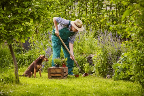 Gardener working in a Charlton front garden with tools